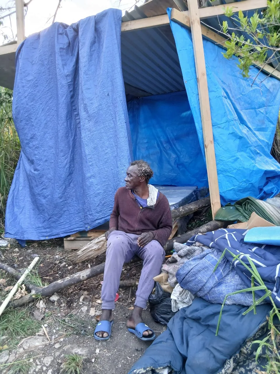 A Jamaican resident standing near storm damage